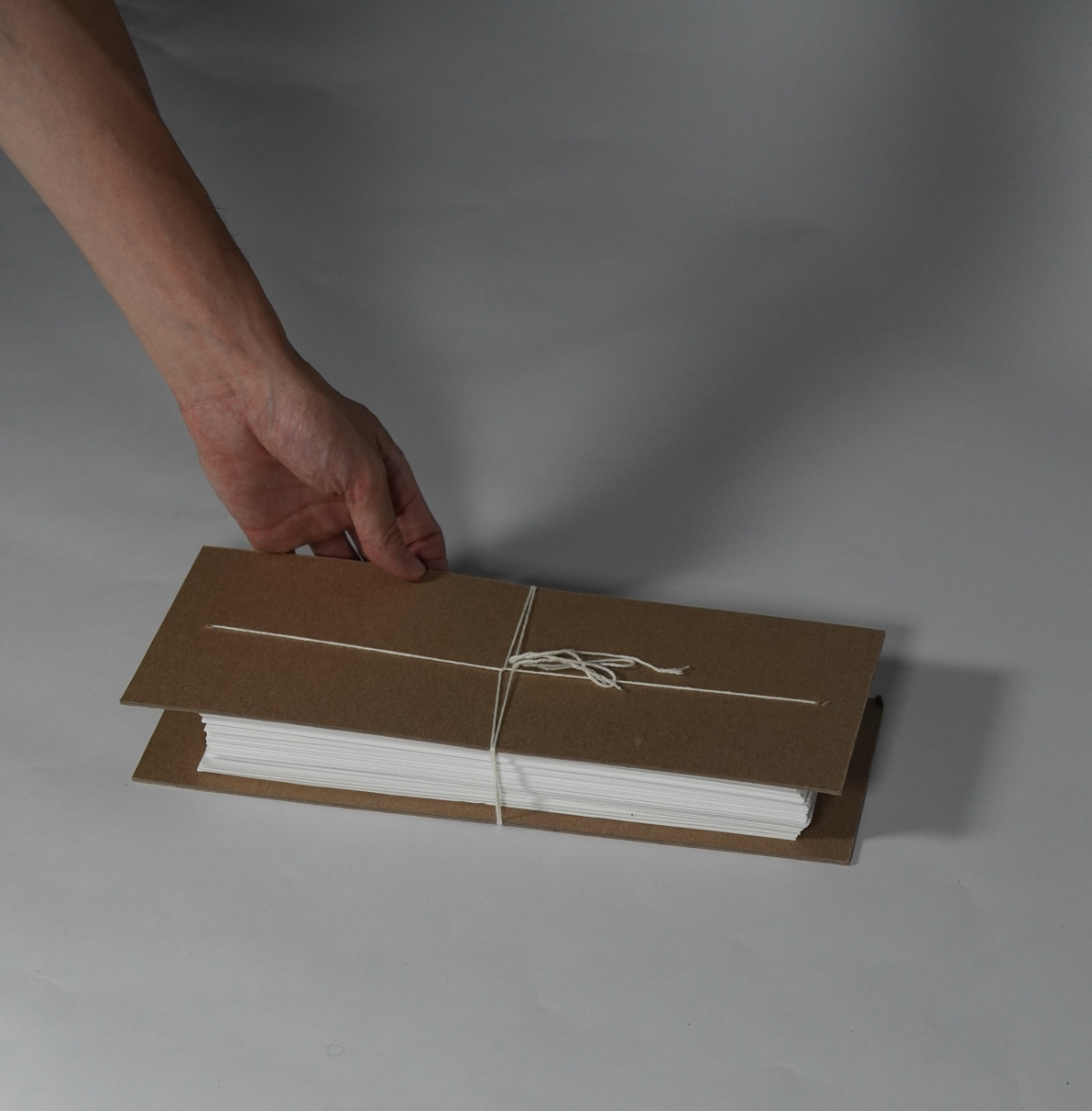 A hand holding a stack of papers
